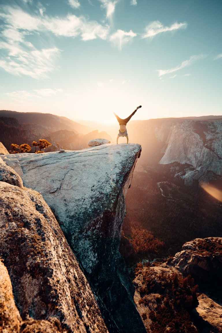 man doing hand stand on mountain